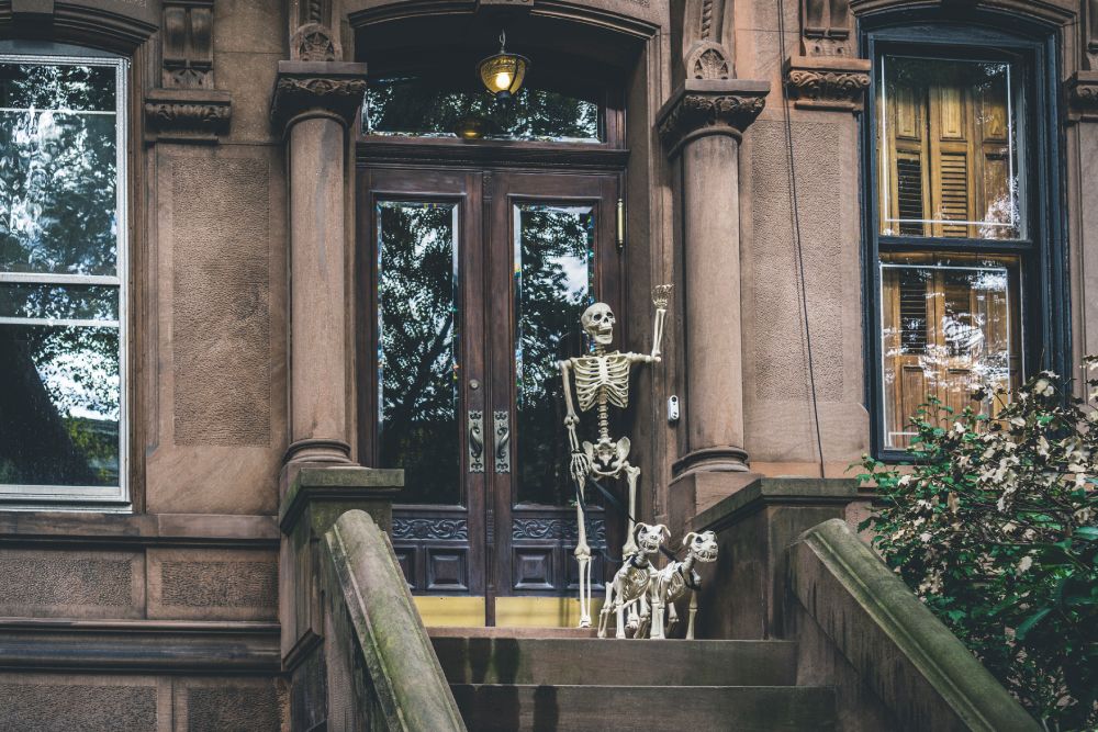 Halloween decorations of a skeleton and skeleton dogs waving to guests of the James NoMad