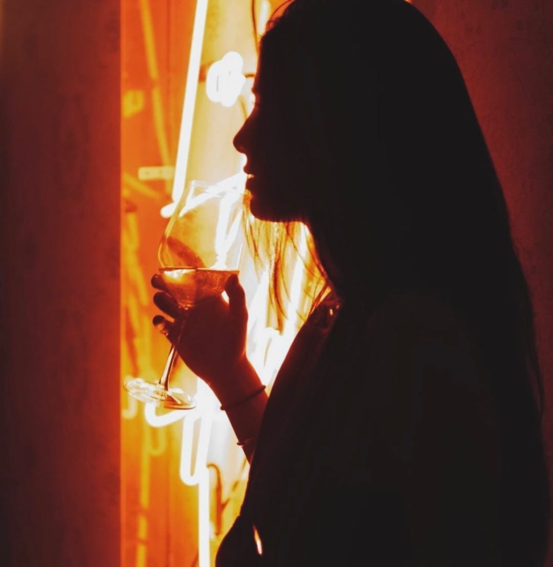 A silhouette of a woman enjoying a drink during the holiday season